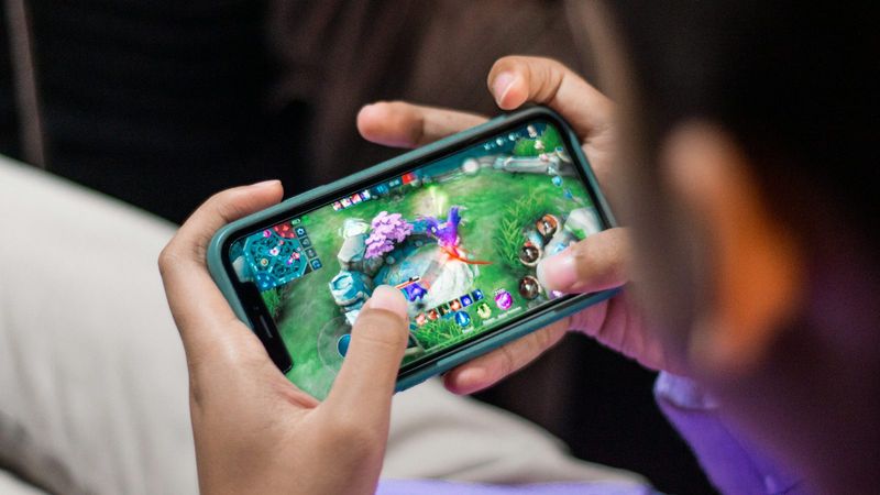 Zwei Hände spielen quer auf dem Smartphone, so fühlt sich ein Handy Casino an