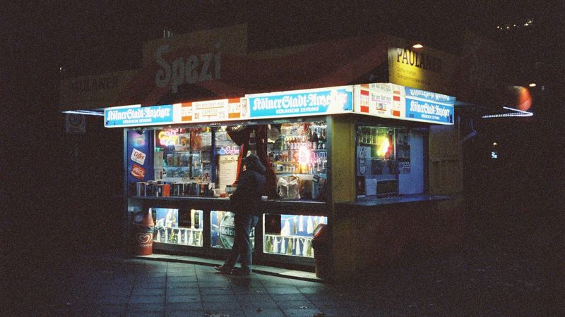 Beleuchteter Kiosk bei Nacht, wo man den Code für ein Paysafecard Casino kauft