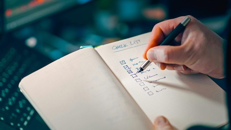 Hand hakt eine Checkliste im Notizbuch ab, so testen wir jedes Online Casino