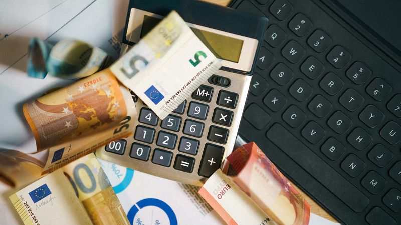 Taschenrechner auf Euroscheinen, offen erklärt, wie wir Geld verdienen